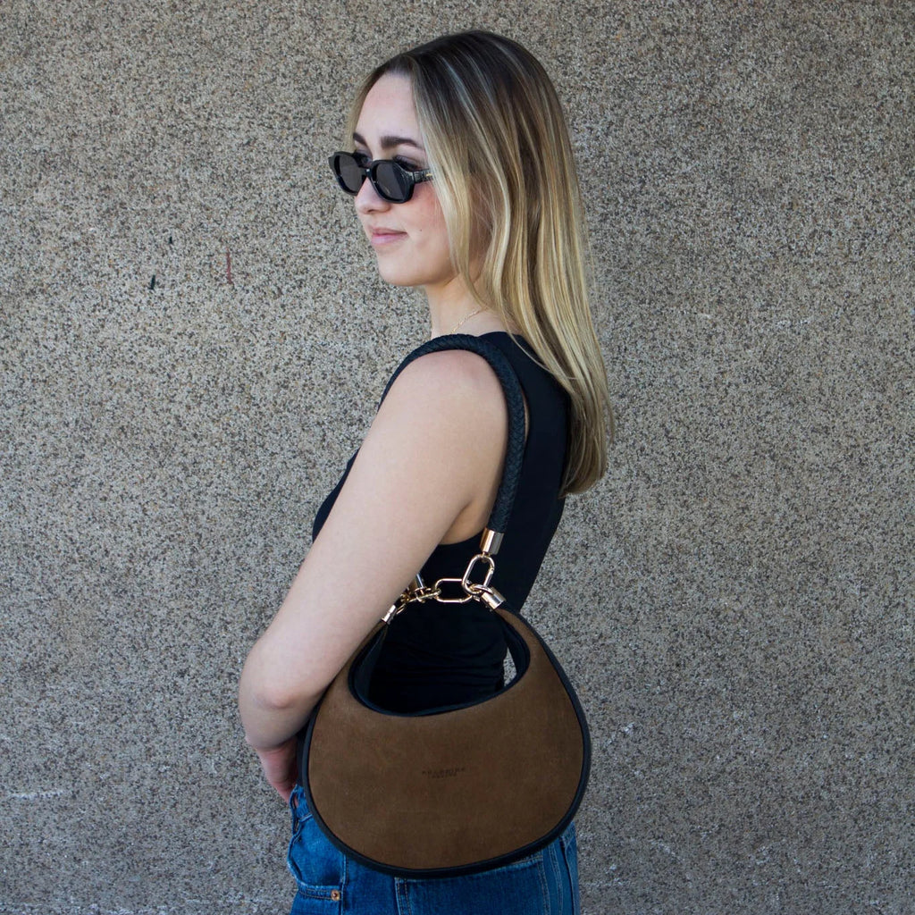 Camelia: La pieza más versátil

Se diseñó Camelia para ser esa bolsa que se adapta a cualquier plan. Es best seller porque te ofrece 3 formas de uso en una sola pieza:

Cruzada: Con su strap largo para los días de movimiento.

Al hombro: Con su asa trenzada a mano, el detalle artesanal que la hace única.

Efecto "Dumpling": Usa el ganchito interno para darle esa forma orgánica y compacta que tanto nos gusta.