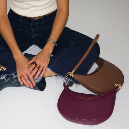 Camelia: La pieza más versátil

Se diseñó Camelia para ser esa bolsa que se adapta a cualquier plan. Es best seller porque te ofrece 3 formas de uso en una sola pieza:

Cruzada: Con su strap largo para los días de movimiento.

Al hombro: Con su asa trenzada a mano, el detalle artesanal que la hace única.

Efecto "Dumpling": Usa el ganchito interno para darle esa forma orgánica y compacta que tanto nos gusta.